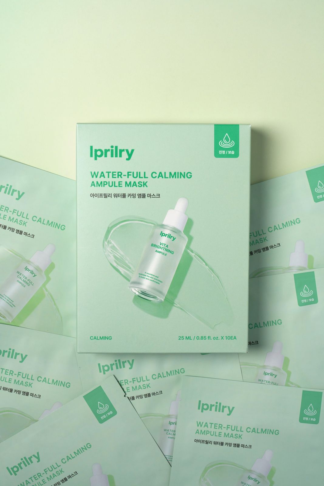 Iprilry · 아이프릴리 카밍마스크 — 박스와 낱개 파우치들을 함께 배치한 메인 패키지 컷, 그린 배경