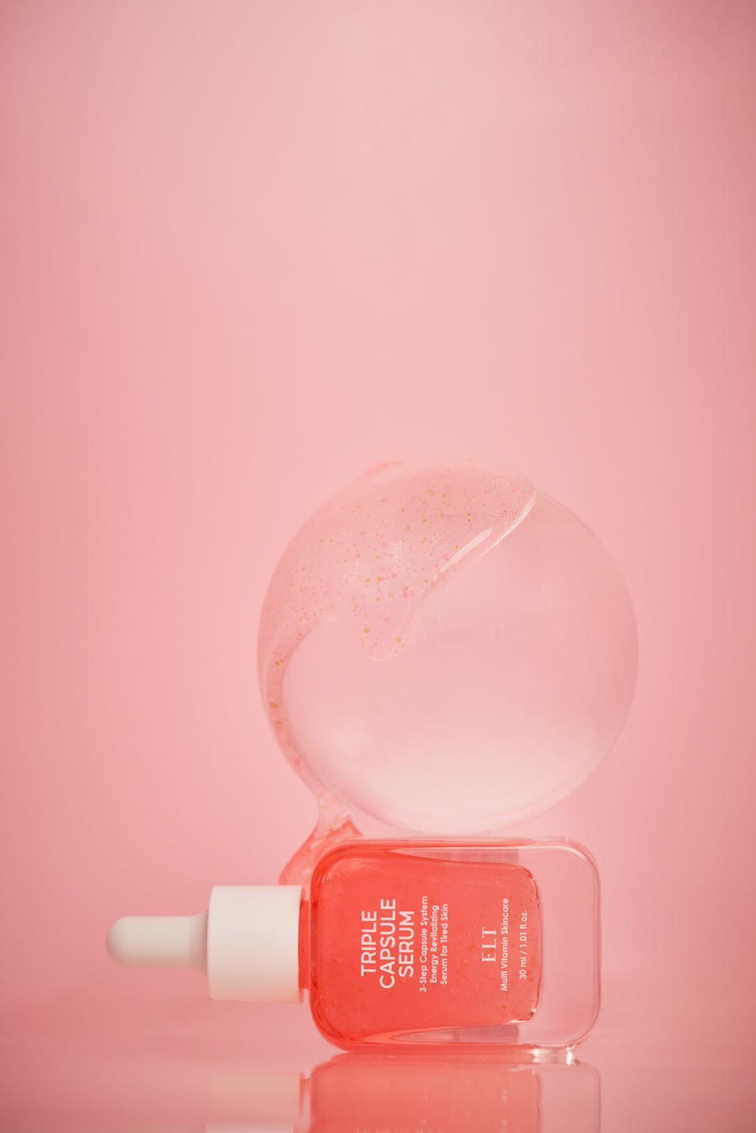 ELT COSMETIC · 캡슐세럼 — 제품 뒤로 거대한 투명 텍스처 버블이 떠 있는 합성이펙트 연출컷