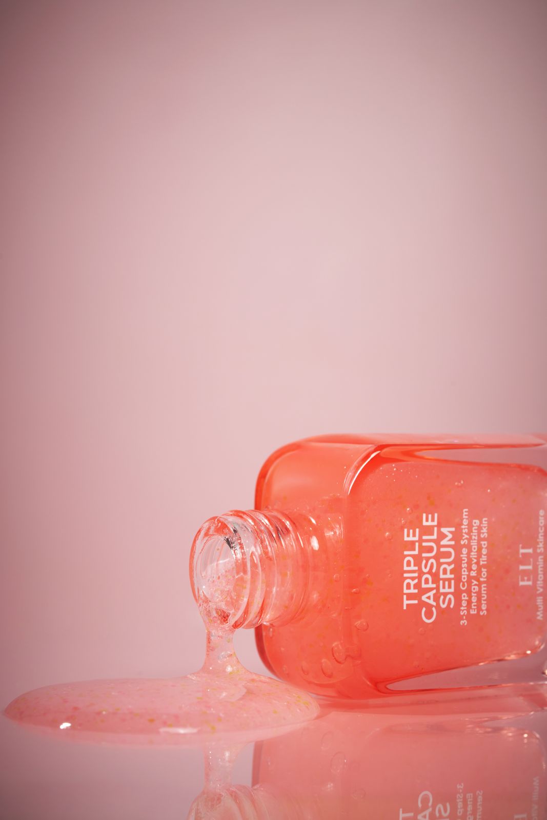 ELT COSMETIC · 캡슐세럼 — 병을 기울여 세럼이 흘러나와 바닥에 고이는 연출컷