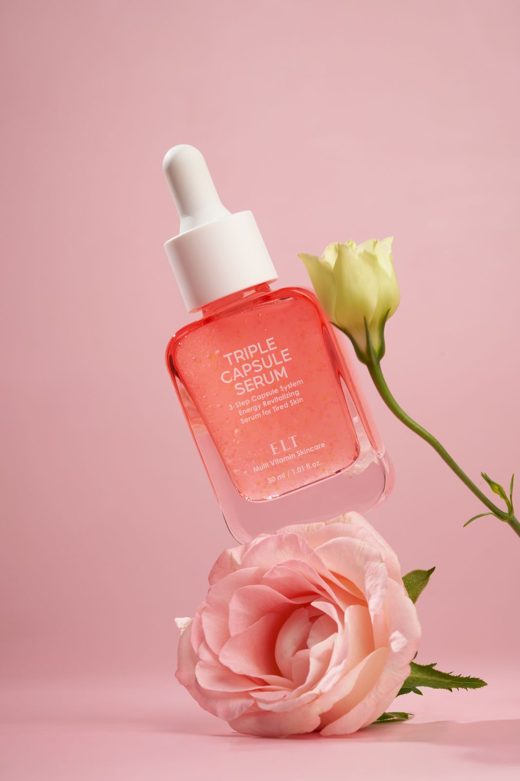 ELT COSMETIC · 캡슐세럼 — 핑크 장미와 함께 공중에 떠 있는 병 연출컷