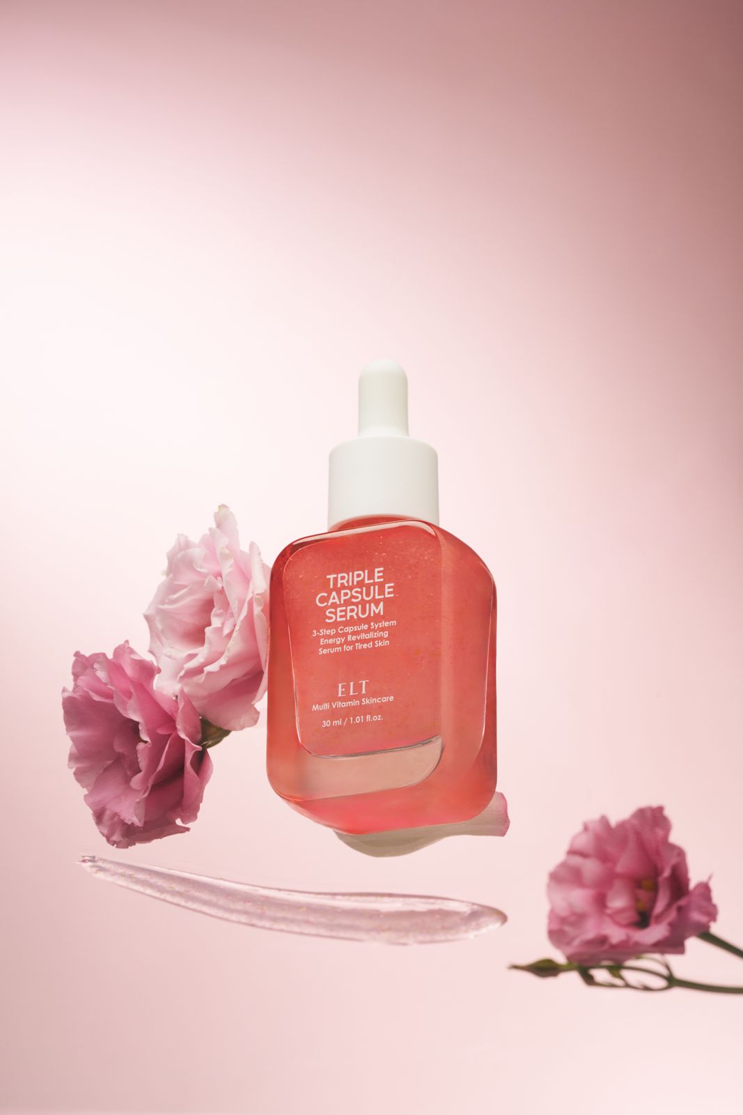 ELT COSMETIC · 캡슐세럼 — 핑크 꽃송이들과 텍스처 스와치가 함께 놓인 공중부양 연출컷