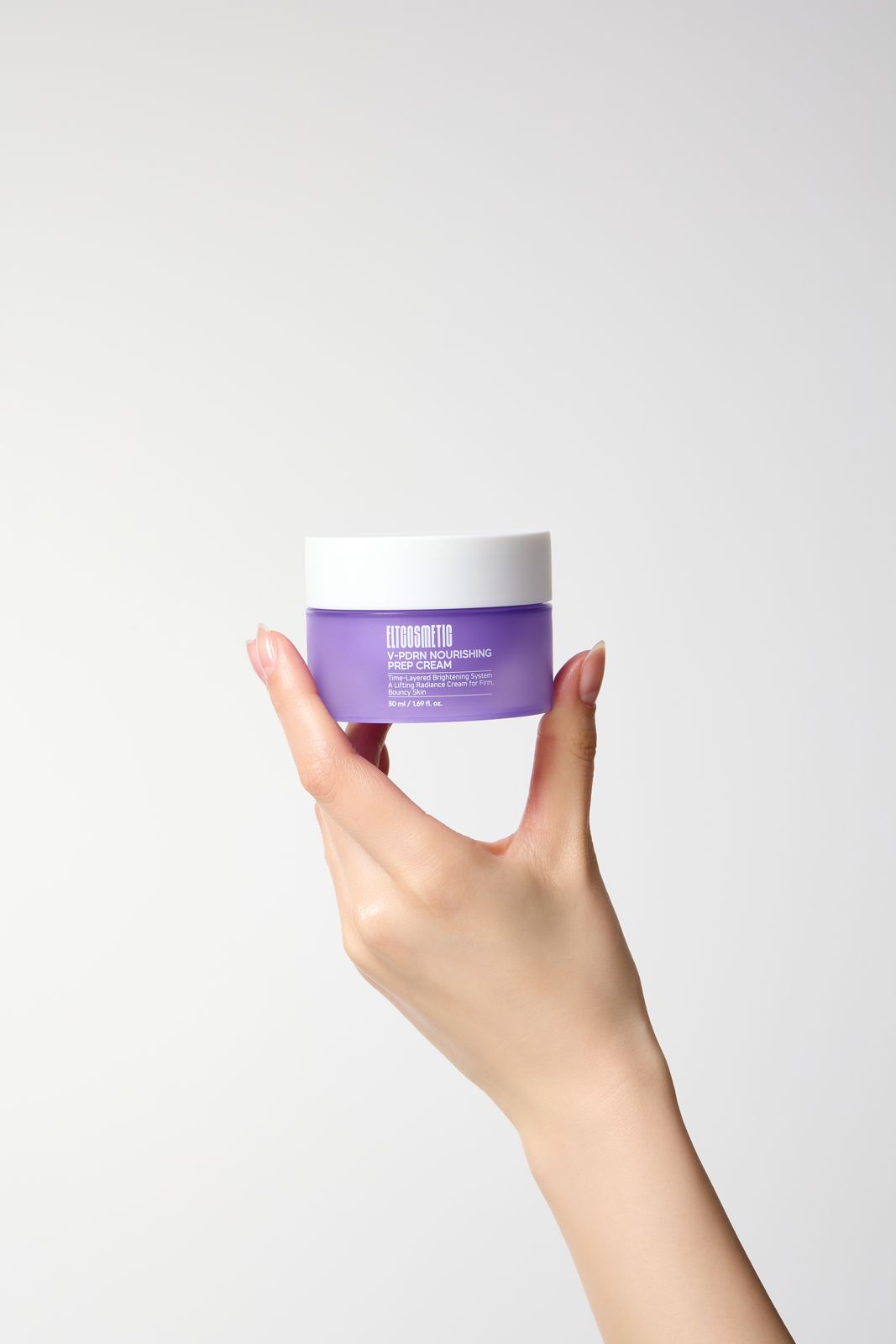 ELT COSMETIC · V-PDRN 크림 — 화이트 배경, 손으로 제품 용기를 들어올린 손모델컷