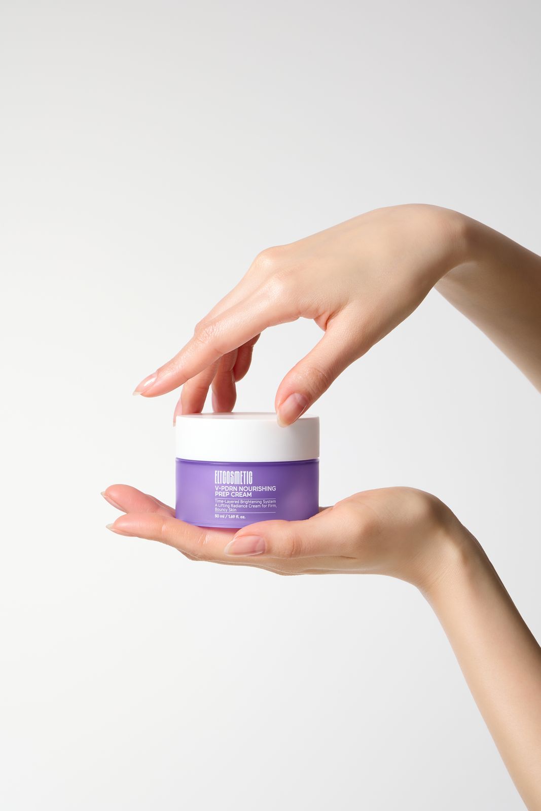 ELT COSMETIC · V-PDRN 크림 — 한 손으로 받치고 다른 손으로 뚜껑을 열려는 두 손 모델컷