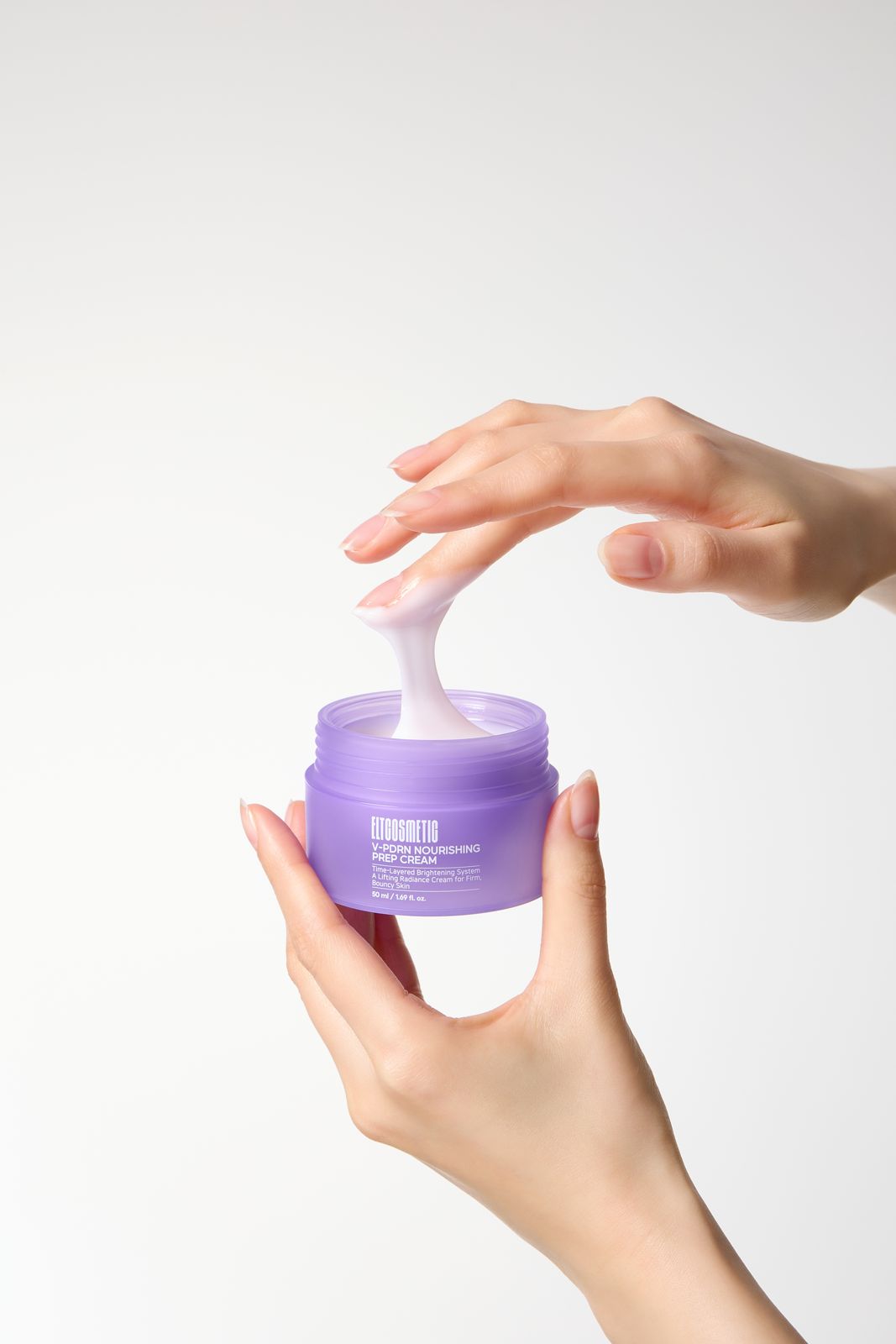 ELT COSMETIC · V-PDRN 크림 — 한 손으로 뚜껑 열린 용기를 들고 다른 손가락으로 제형을 떠올리는 손모델컷