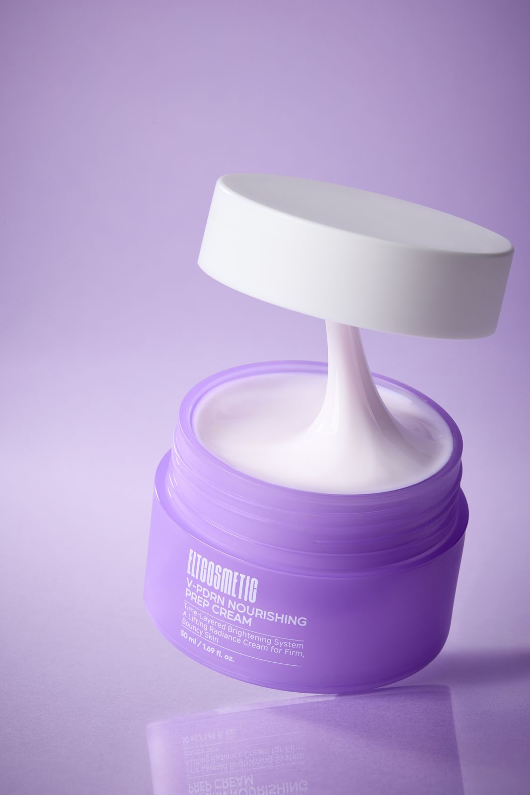 ELT COSMETIC · V-PDRN 크림 — 퍼플 그라데이션 배경, 뚜껑을 들어올려 제형이 늘어난 연출컷