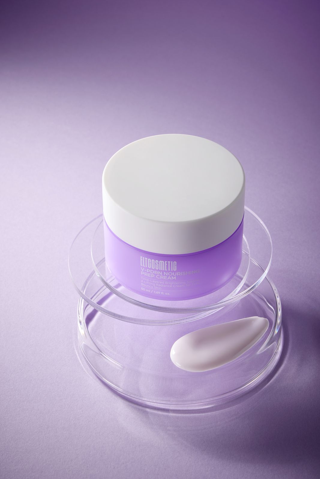 ELT COSMETIC · V-PDRN 크림 — 퍼플 배경, 유리 샬레 2단 위에 용기를 올리고 아래 샬레에 제형 스와치를 놓은 연출컷
