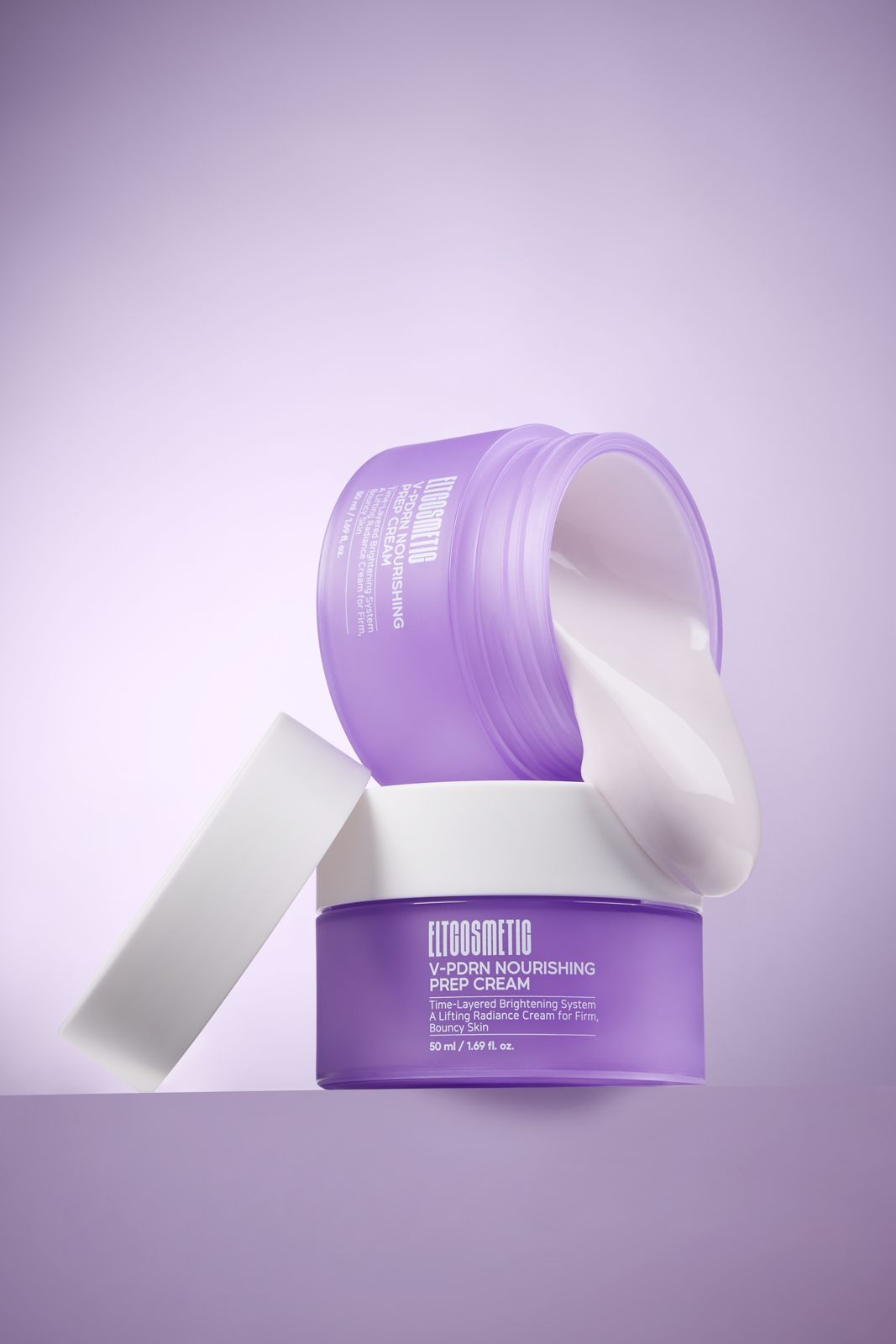 ELT COSMETIC · V-PDRN 크림 — 용기 2개를 쌓고 하나는 뒤집어 제형을 보여주는 연출컷, 뚜껑은 따로 기대어 놓음