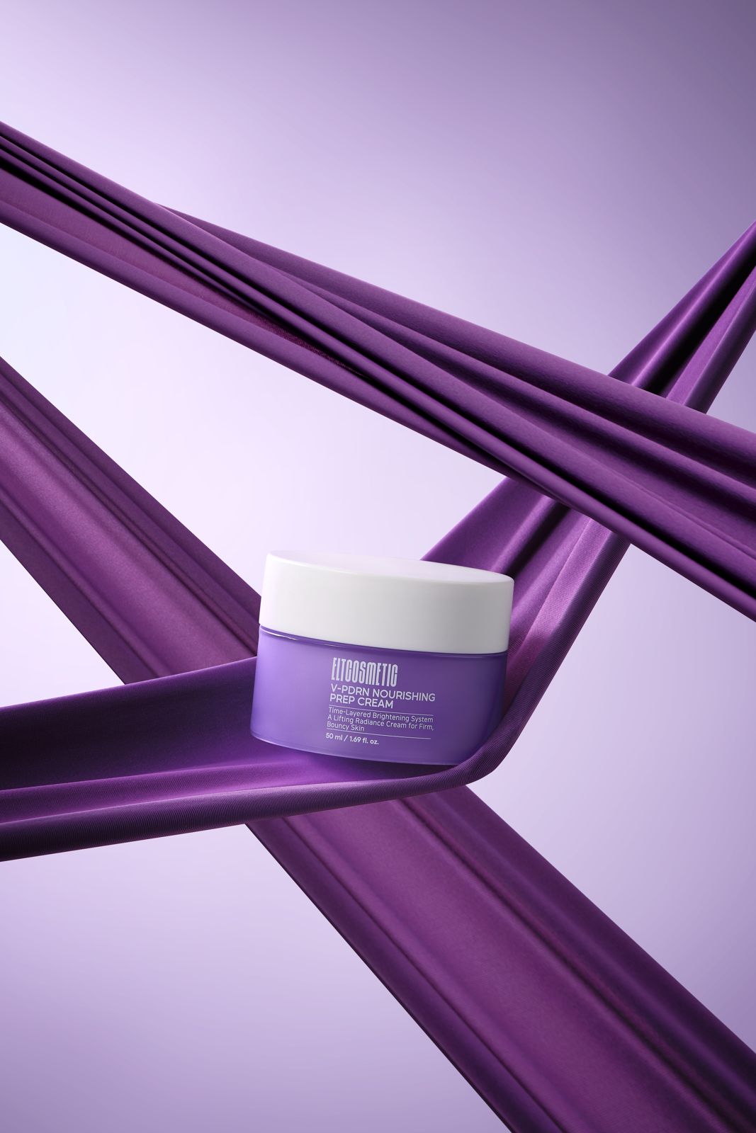 ELT COSMETIC · V-PDRN 크림 — 퍼플 새틴 패브릭이 교차하는 위에 용기를 올린 럭셔리 연출컷