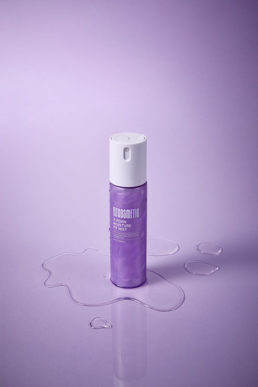 ELT COSMETIC · V-PDRN 미스트 — 바닥에 퍼진 물웅덩이 위에 세운 단독 병컷