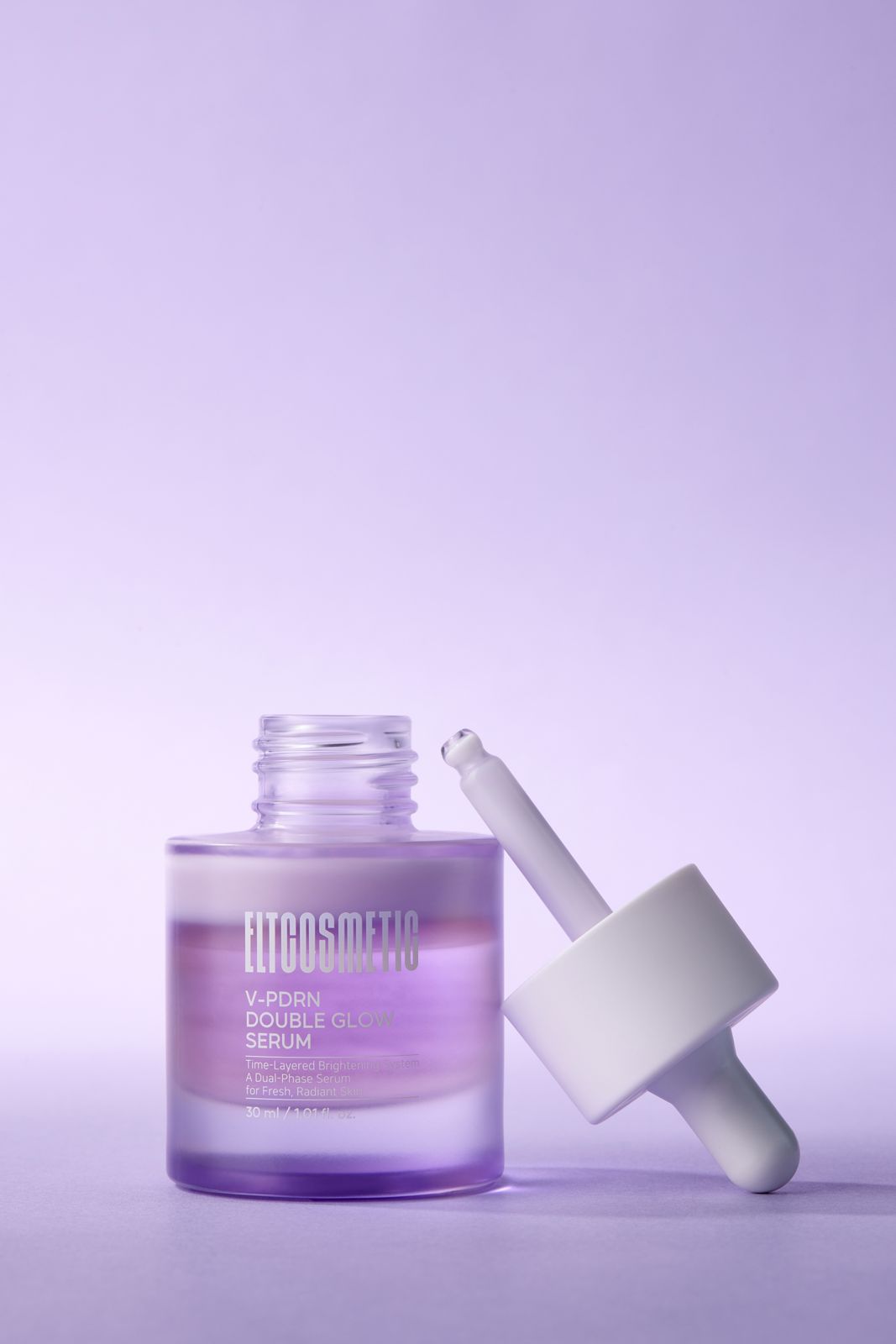 ELT COSMETIC · V-PDRN 세럼 — 뚜껑이 열린 제품 옆에 뚜껑 스포이드를 대각선으로 기댄 연출컷