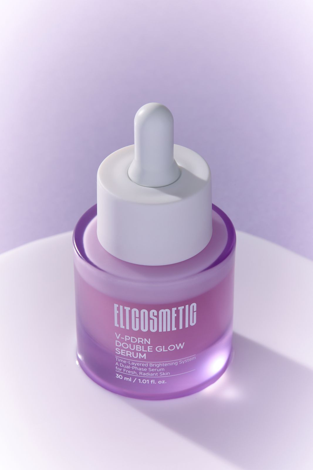 ELT COSMETIC · V-PDRN 세럼 — 흰색 액체 제형 위로 병을 세운 연출컷,