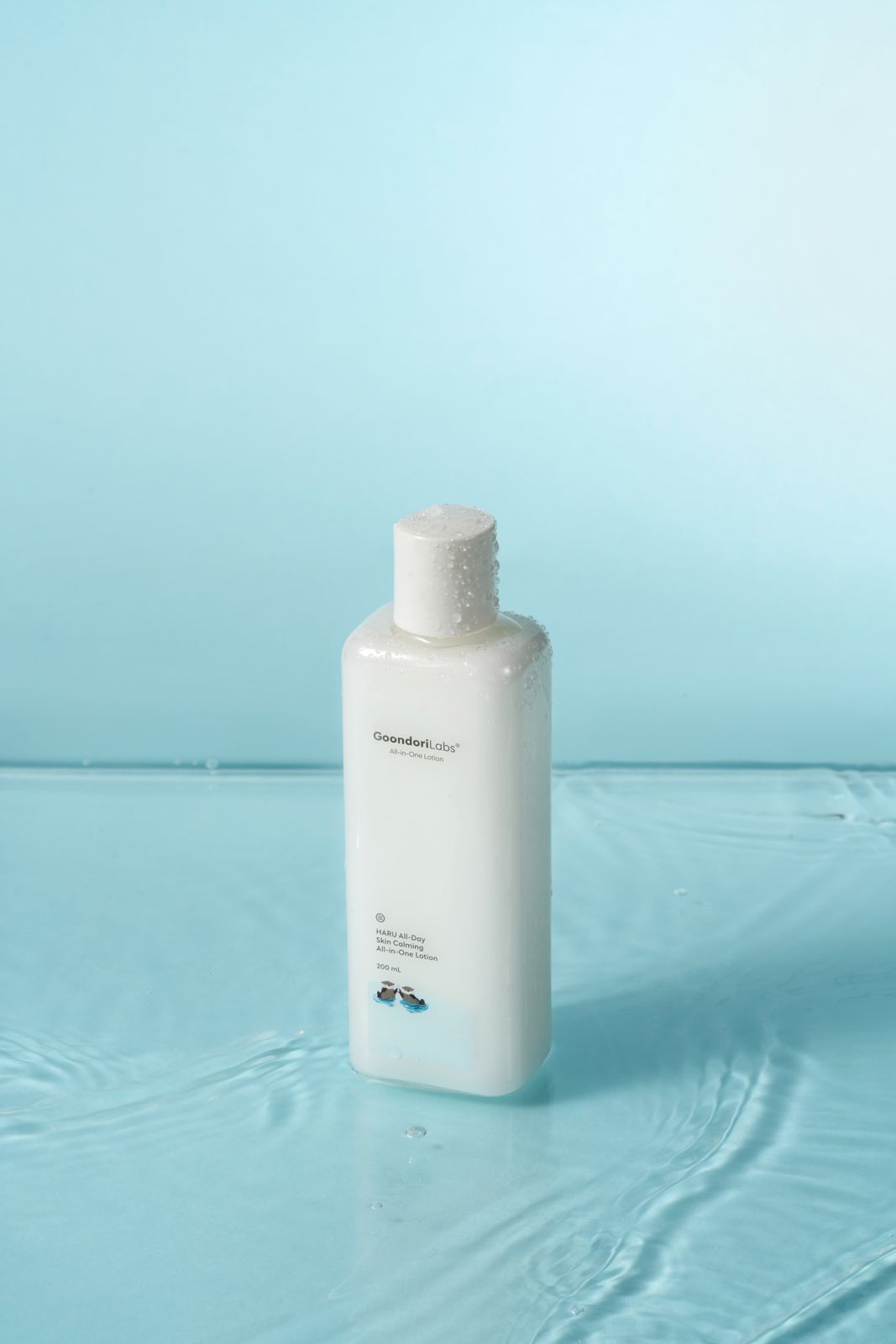 Goondori Labs · 제품촬영 — 로션이 물 위에 놓임, 수면 잔물결·물방울