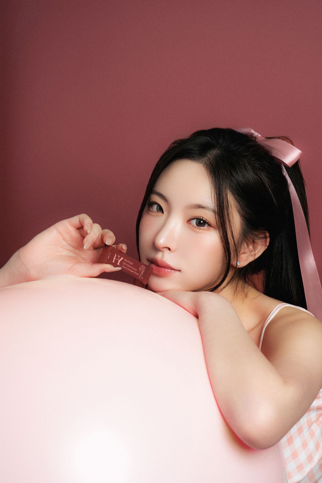 HANYAN · 건강기능식품 (모델컷) — 새틴 리본 헤어 장식, 쿠션에 팔을 얹고 사쉐를 든 모델컷