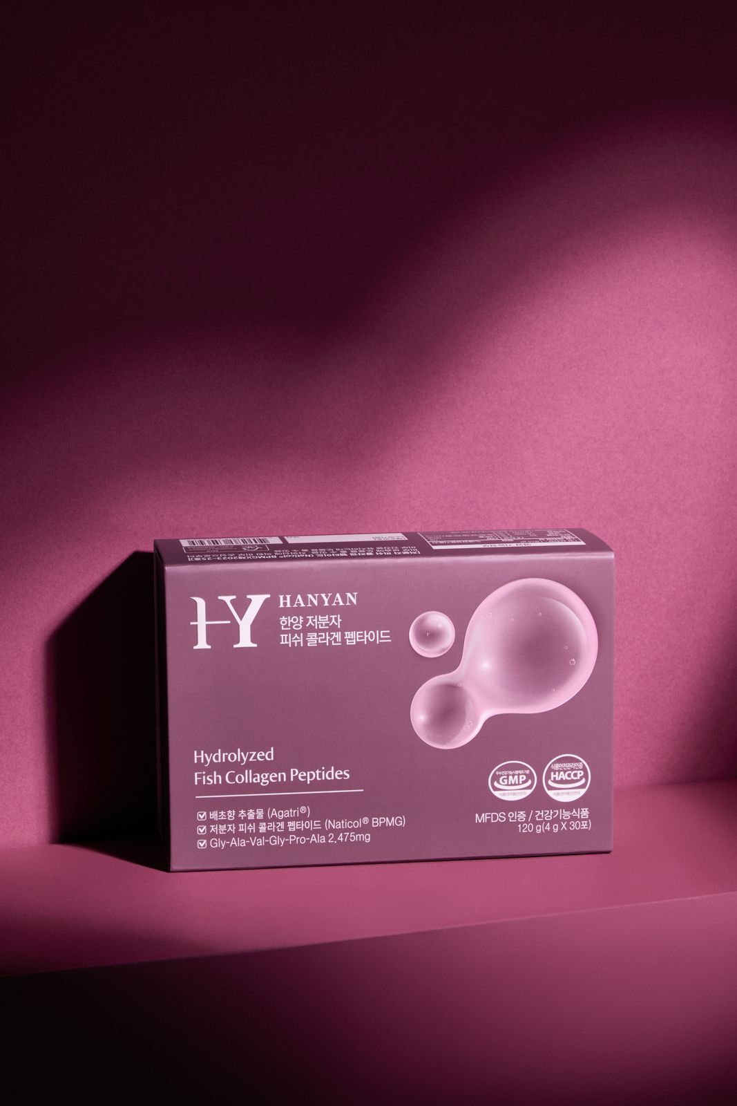 HANYAN · 건강기능식품 — 짙은 핑크 배경에 사이드 조명을 준 단독 박스 연출컷