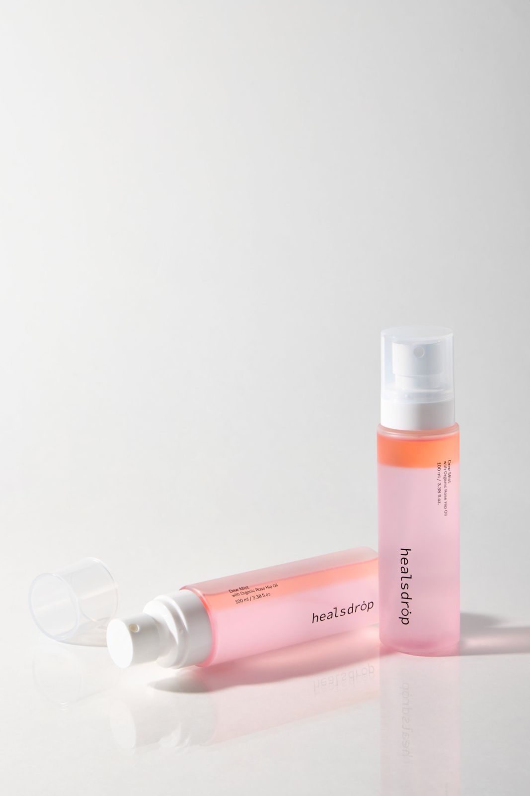 HEALSDROP · 미스트 — 뚜껑을 연 채 눕힌 제품과 세워둔 제품을 함께 배치한 컷, 화이트 배경