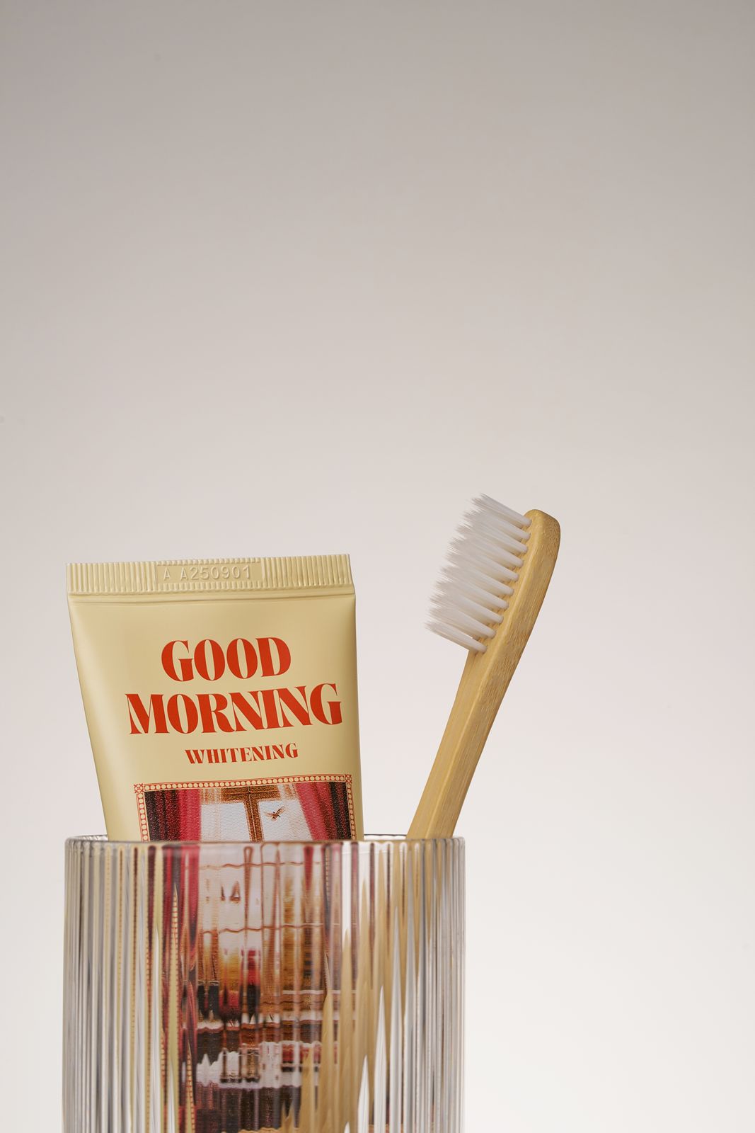 HEALTHY TEETH PLUS · 올데이케어 치약 — 굿모닝 치약과 나무 칫솔이 담긴 유리컵 클로즈업컷