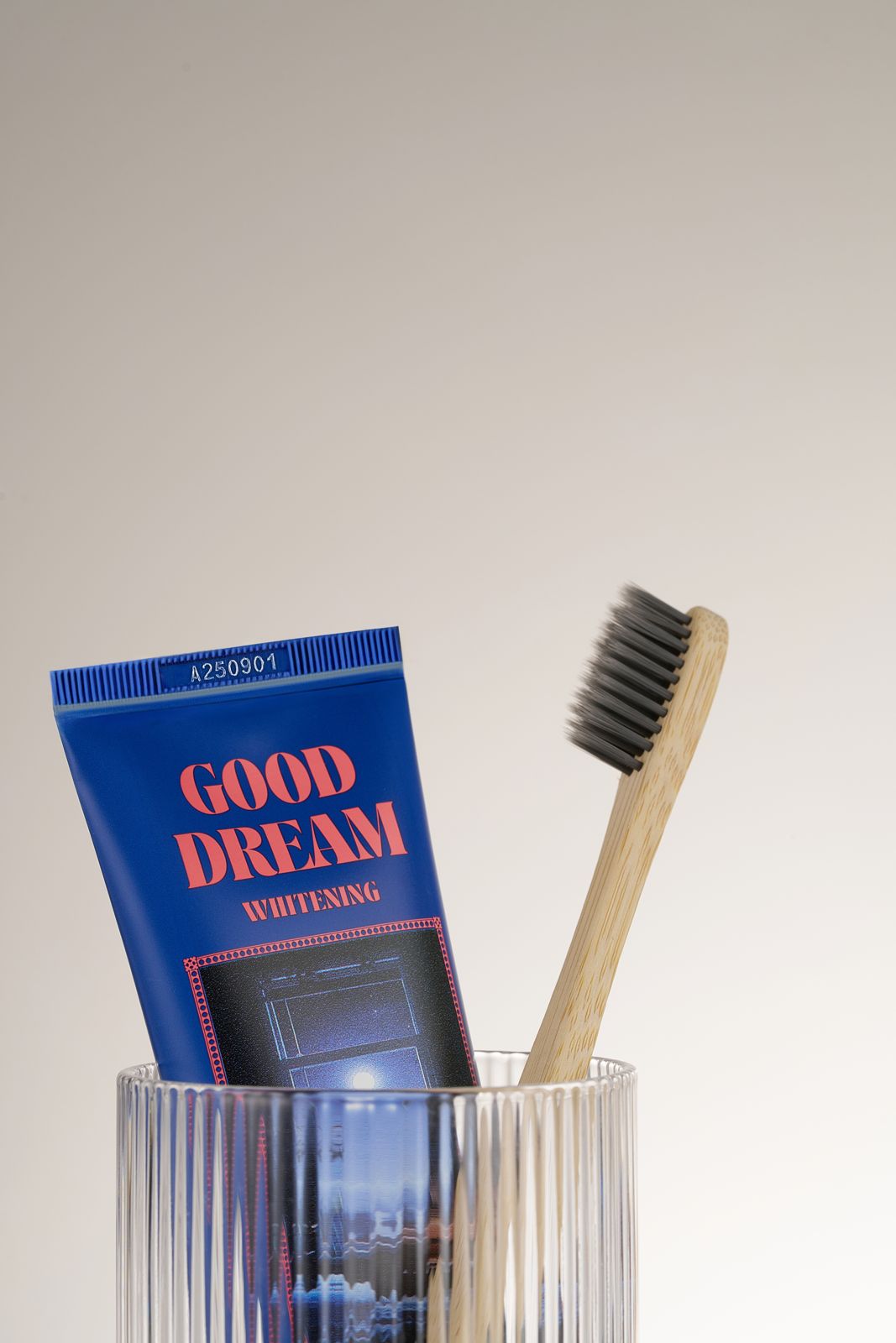 HEALTHY TEETH PLUS · 올데이케어 치약 — 굿드림 치약과 검정모 나무 칫솔이 담긴 유리컵 클로즈업컷