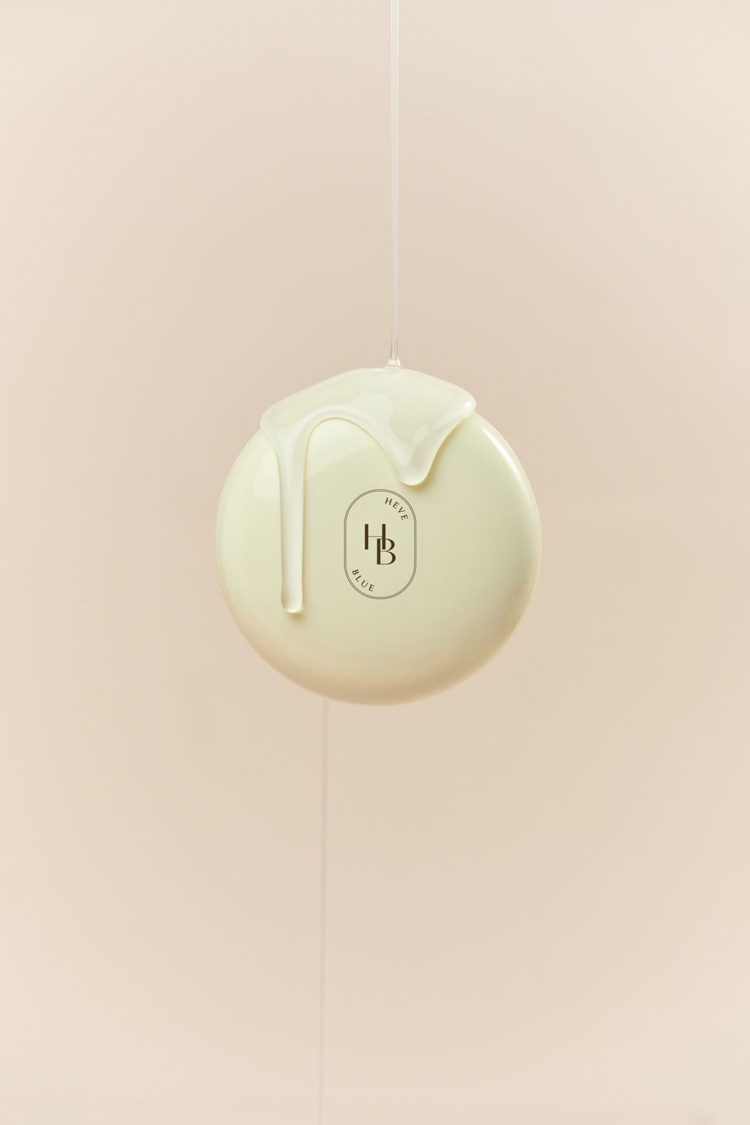 HEVEBLUE · 글로우쿠션 — 닫힌 컴팩트 위로 제형이 흘러내리는 모습을 표현한 텍스처컷, 베이지 배경