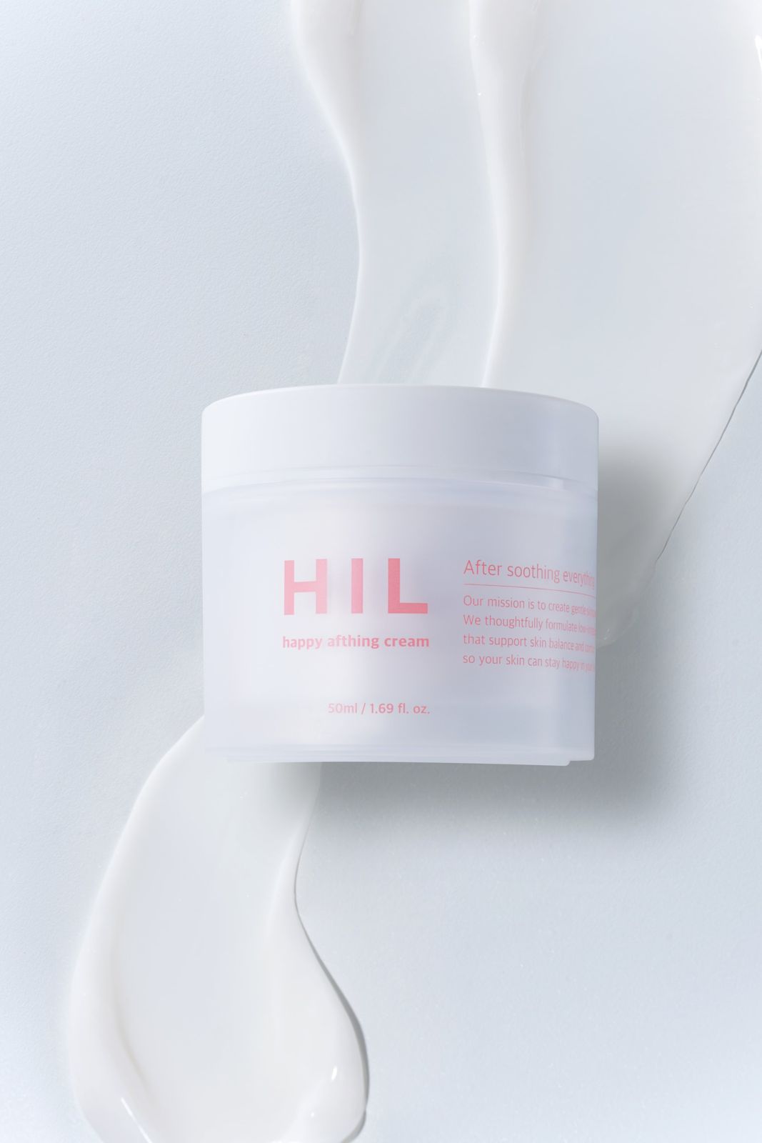 HIL · 크림 — 크림 텍스처를 배경으로 제품을 눕혀 놓은 텍스처컷, 화이트 배경