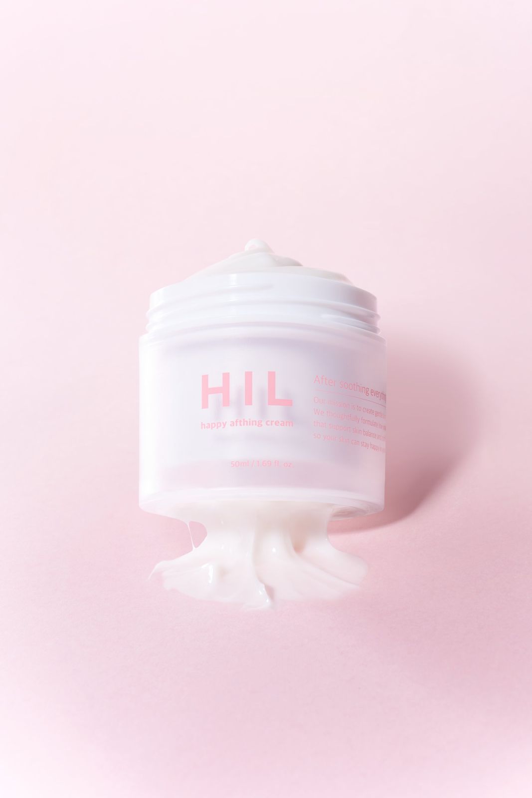 HIL · 크림 — 뚜껑을 열고 크림이 흘러넘치듯 흘러내리는 제형을 표현한 텍스처컷, 핑크 배경
