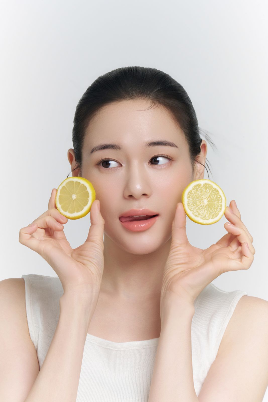 LABIORA · 레몬허니 스킨케어 (모델컷 2) — 레몬 슬라이스 두 개를 양쪽 뺨 옆에 든 컷