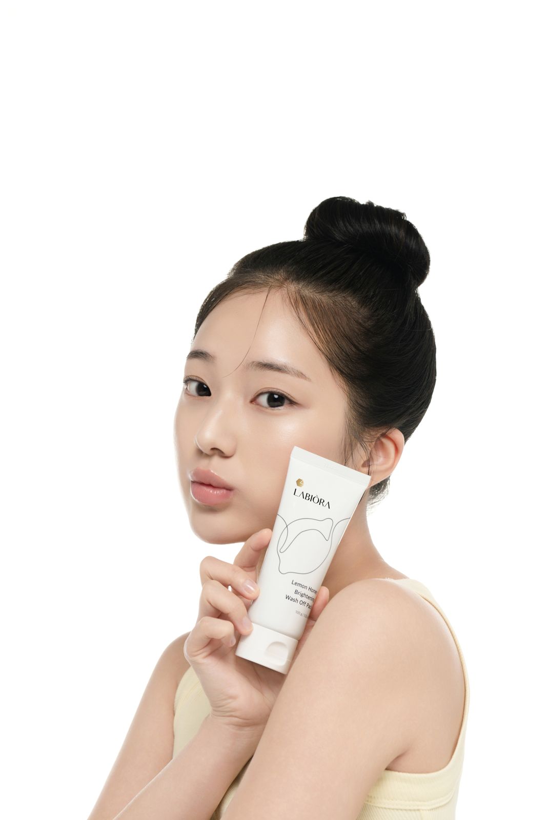 LABIORA · 레몬허니 스킨케어 (모델컷) — 제품을 뺨에 대고 옆모습으로 응시하는 컷