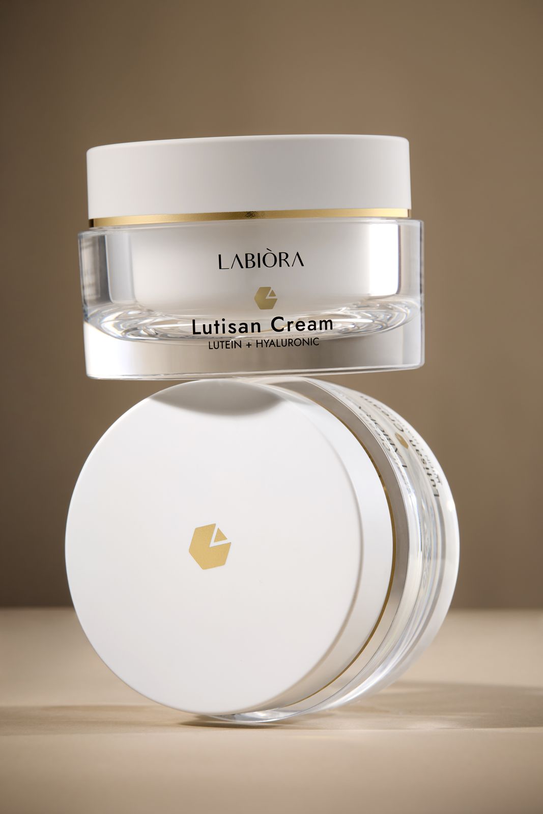 LABIORA · 세럼&크림 — 용기와 뚜껑을 위아래로 쌓은 그룹컷, 따뜻한 그라데이션 배경