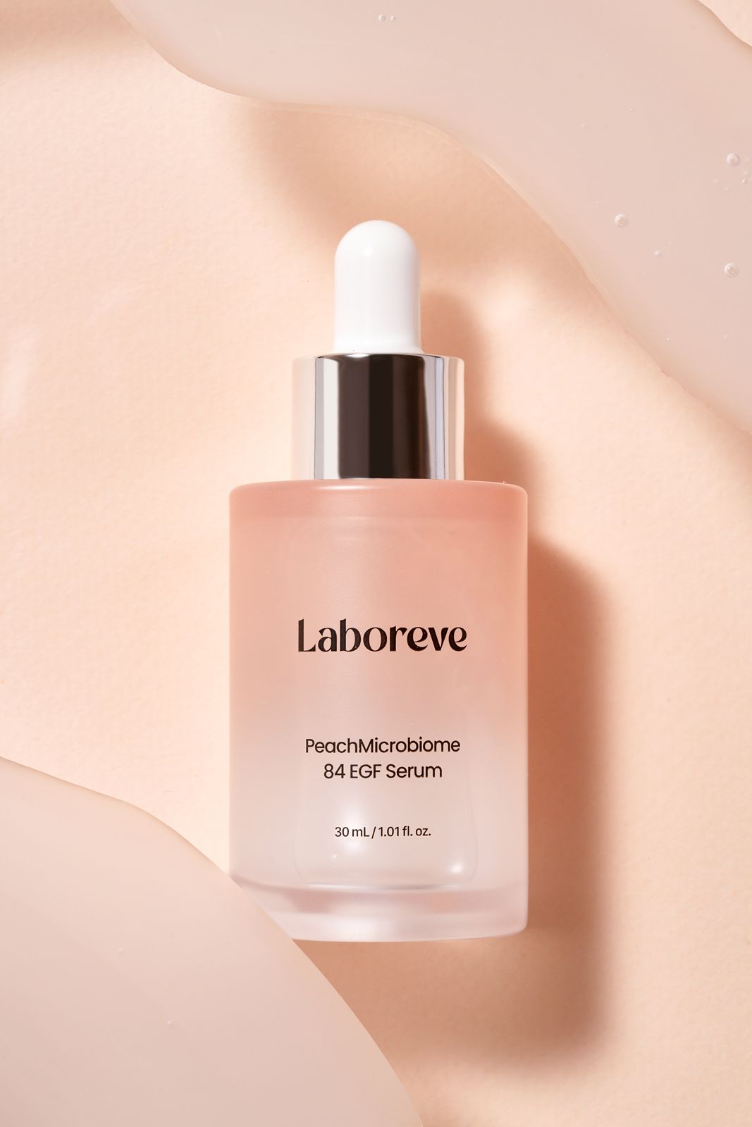 LABOREVE · EGF 세럼 — 웨이브 형태 페이퍼 배경 위에 제품을 눕힌 연출컷