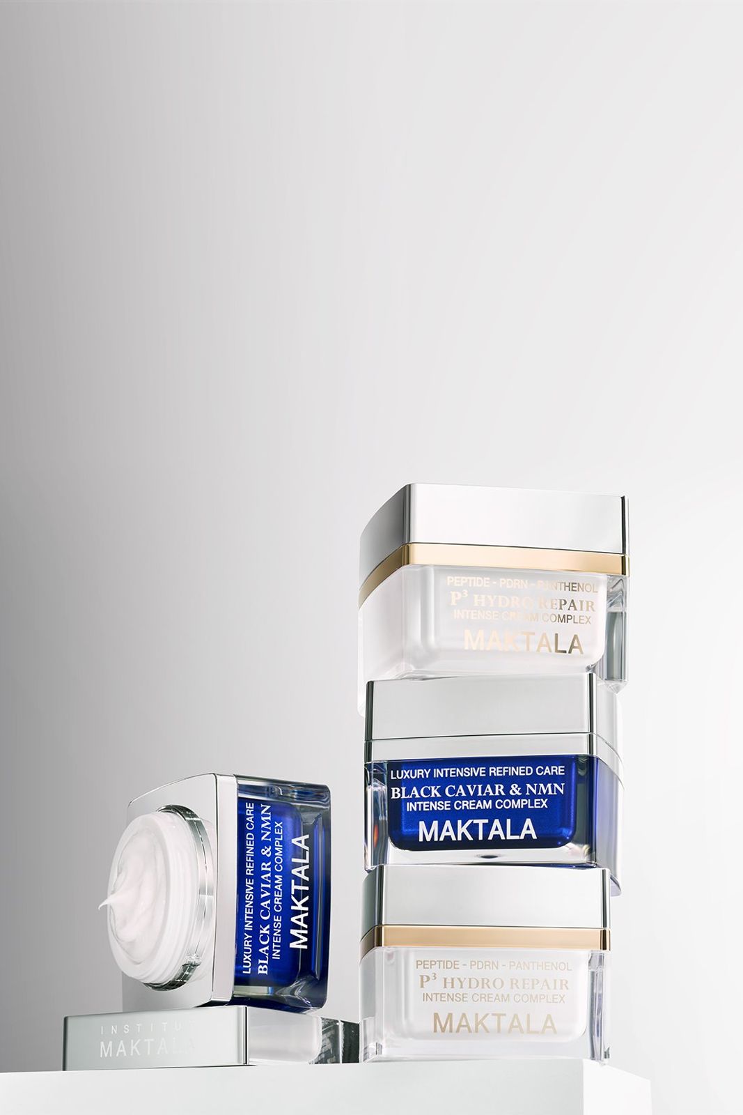 MAKTALA · 크림 — 두 제품 라인업 전체를 그룹으로 배치한 컷, 그레이 그라데이션 배경