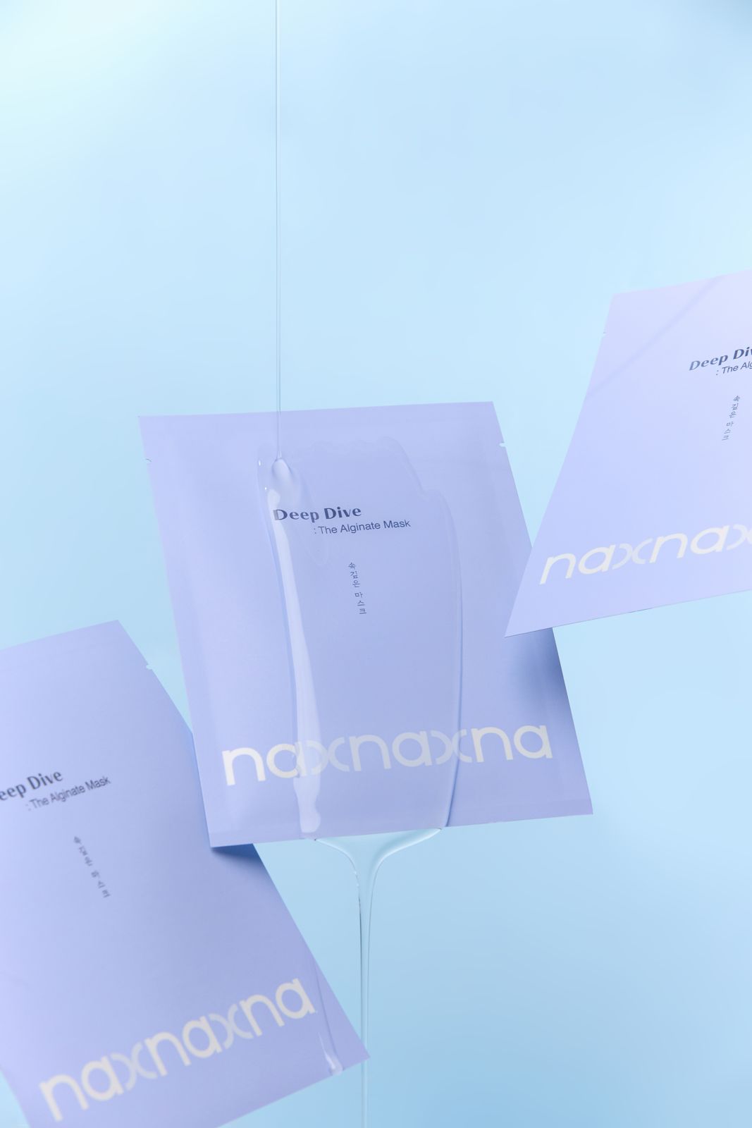 NAXNA · 제품촬영 — 파우치 3개를 띄우고 에센스가 흘러내리는 연출컷