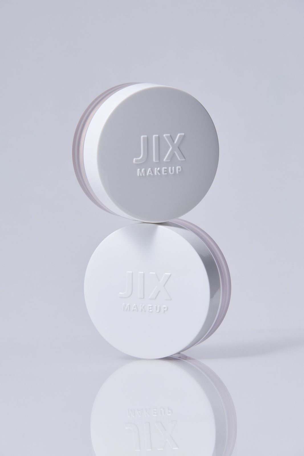 JIX · 파우더 — 제품 2개를 위아래로 쌓아 올린 컷, 리플렉션 있는 그레이 배경