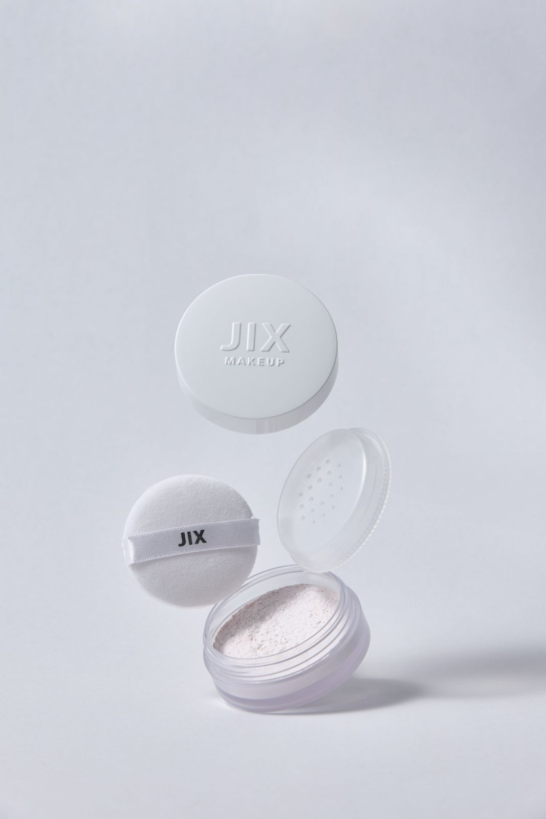 JIX · 파우더 — 본품과 퍼프, 내부 파우더가 담긴 통을 분리해 떠 있는 듯 연출한 컷, 라이트그레이 배경
