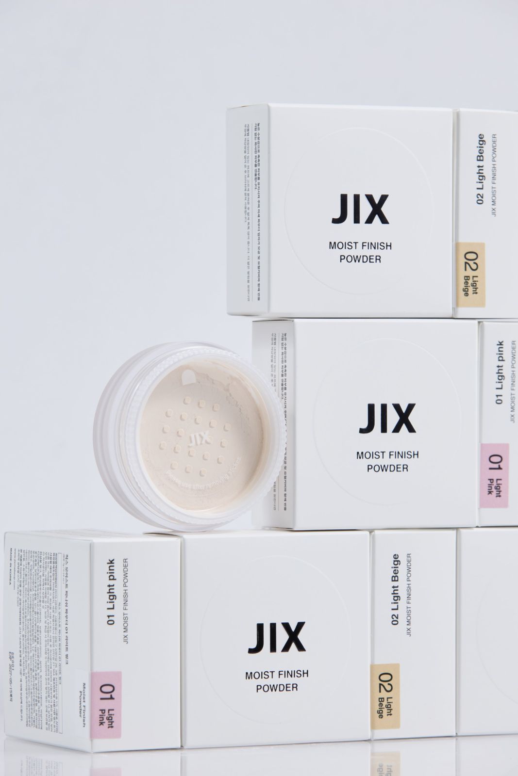 JIX · 파우더 — 본품(오픈된 채로 파우더가 보임)과 컬러별 패키지 박스들을 쌓아 놓은 그룹컷