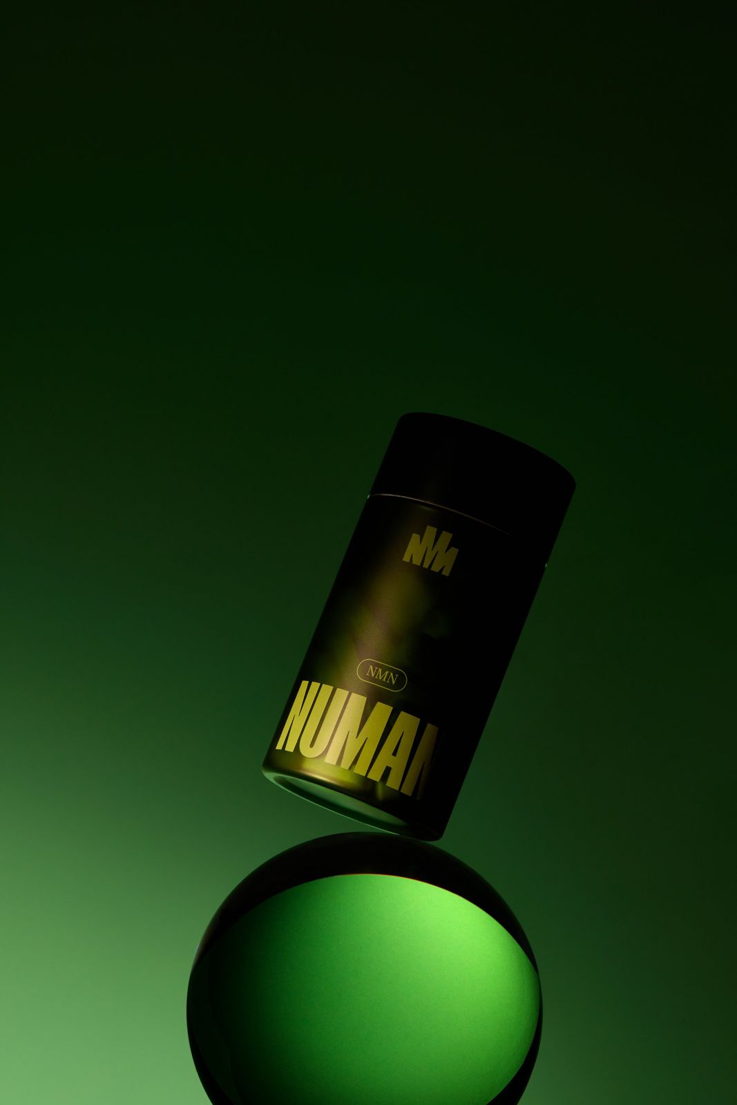 NUMAN · 건강기능식품 — 제품을 크리스탈 볼 위에 띄운 듯 배치한 연출컷, 그린 그라데이션 배경