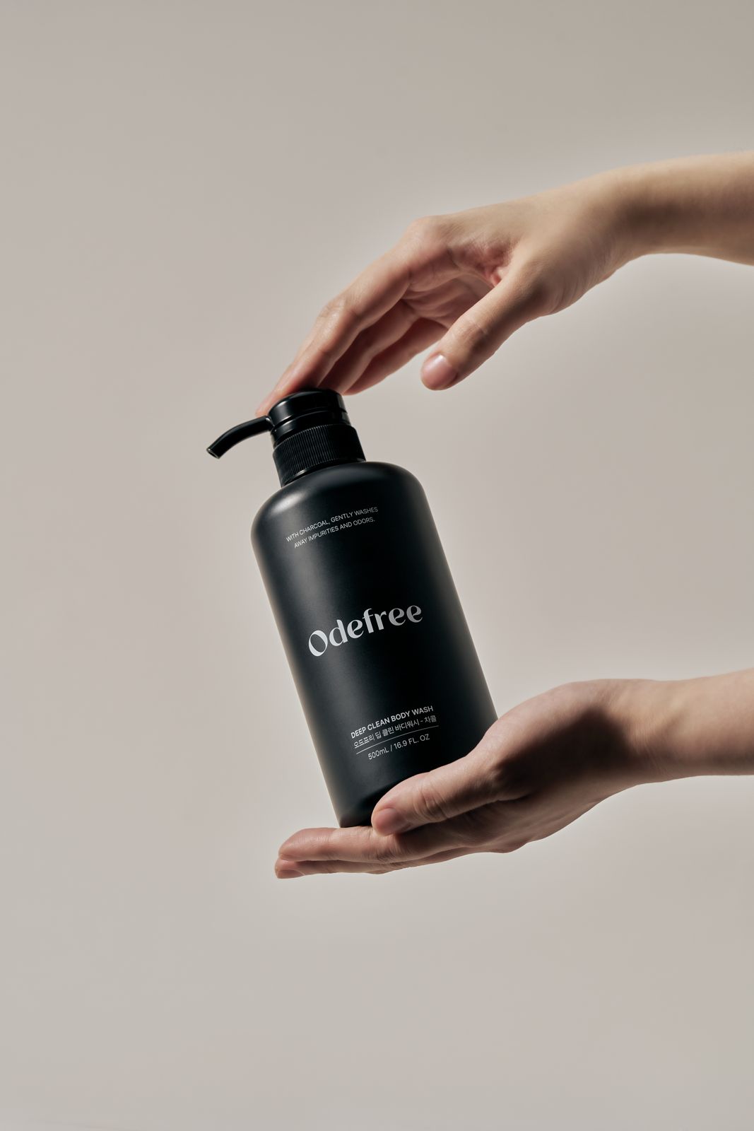 ODEFREE · 바디워시 — 양손으로 용기를 감싸고 펌프를 누르는 손모델컷