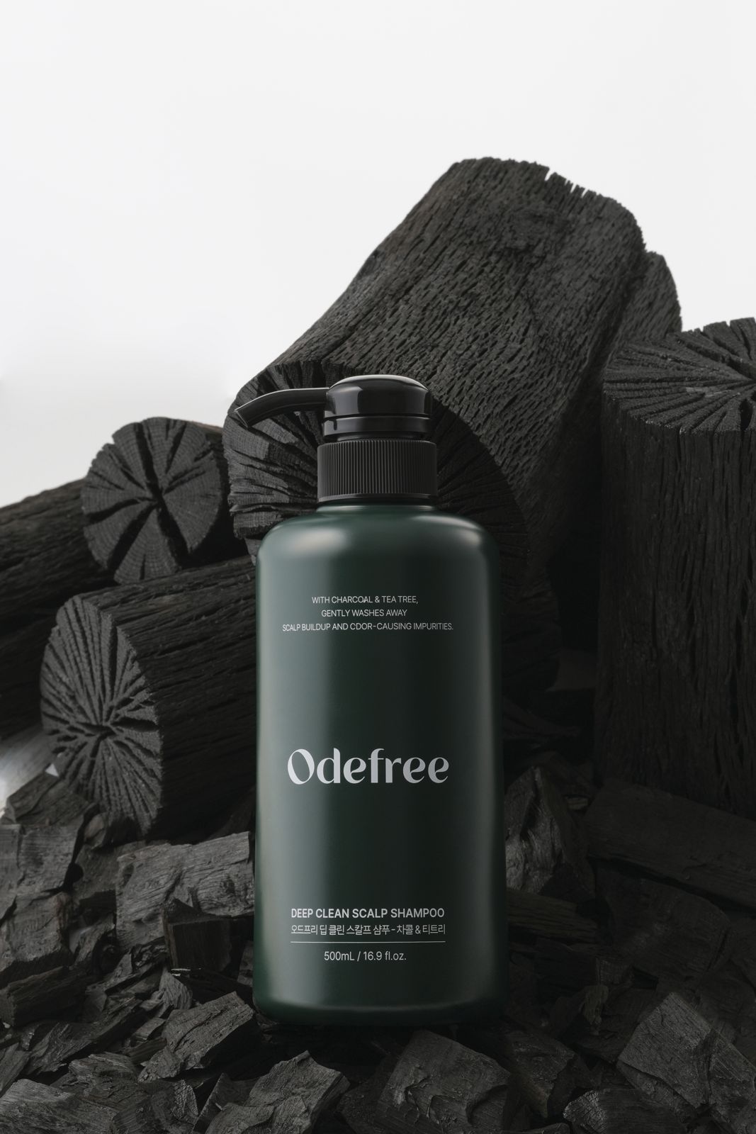 ODEFREE · 샴푸 — 숯더미 위에 용기를 세운 연출컷