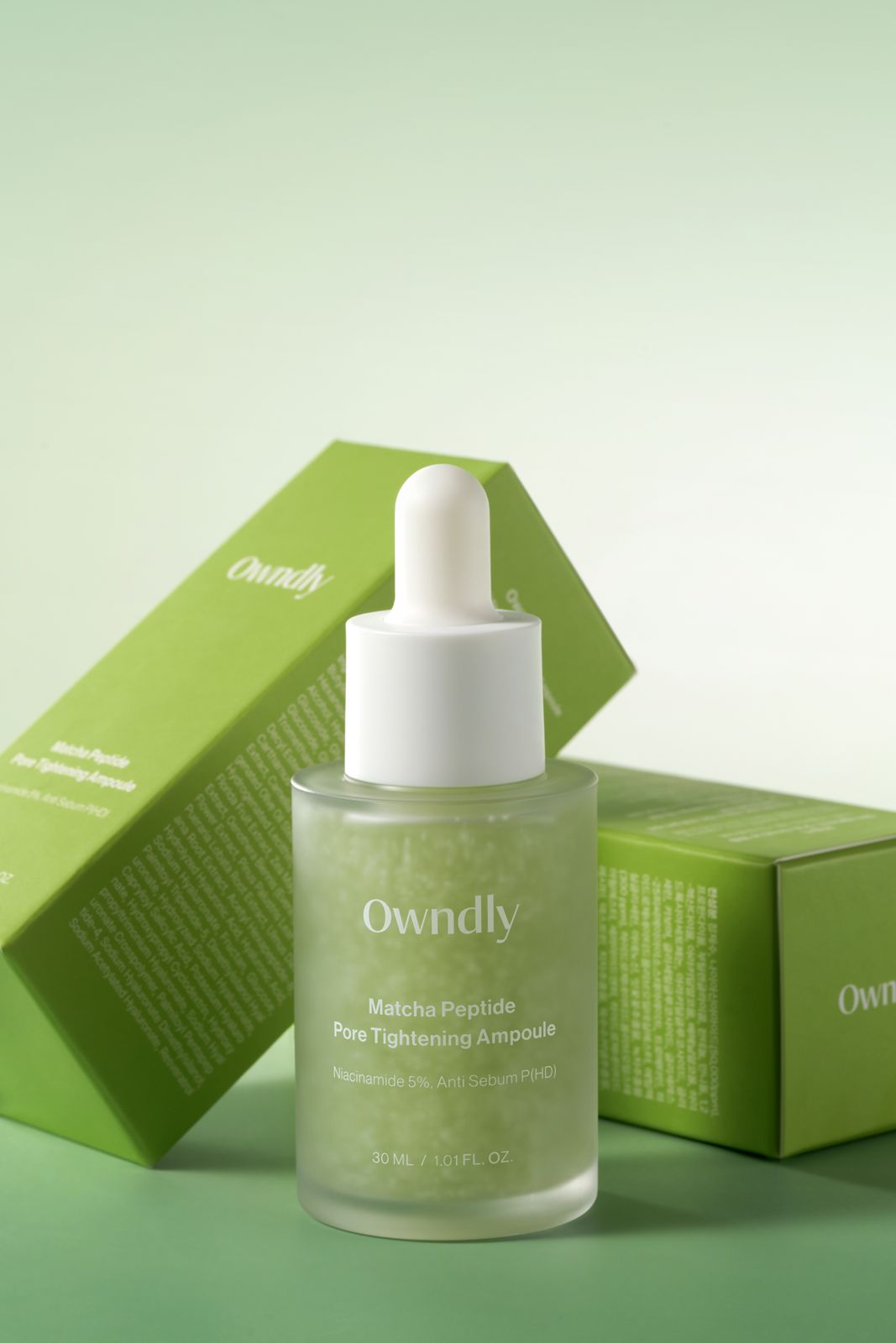 OWNDLY · 모공 타이트닝 앰플 — 병 하나를 세우고 패키지 박스 2개를 뒤에 기대어 놓은 컷