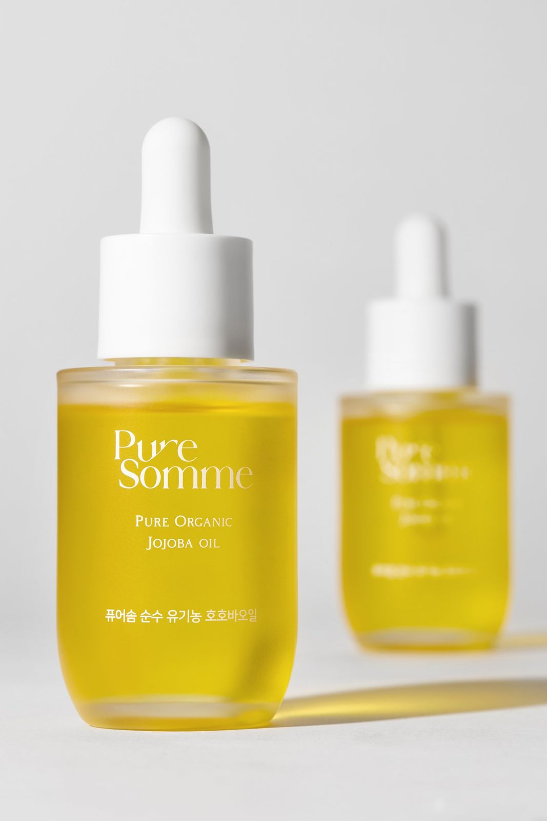 PURESOMME · 호호바오일 — 제품 2개를 나란히 세운 컷, 화이트 배경