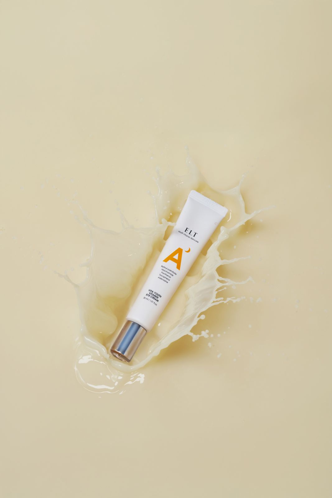 ELT COSMETIC · VITA YOUTH — 베이지 배경 위 튜브 제품이 크리미한 액체가 튀어오른 표면에 놓인 합성이펙트 연출컷