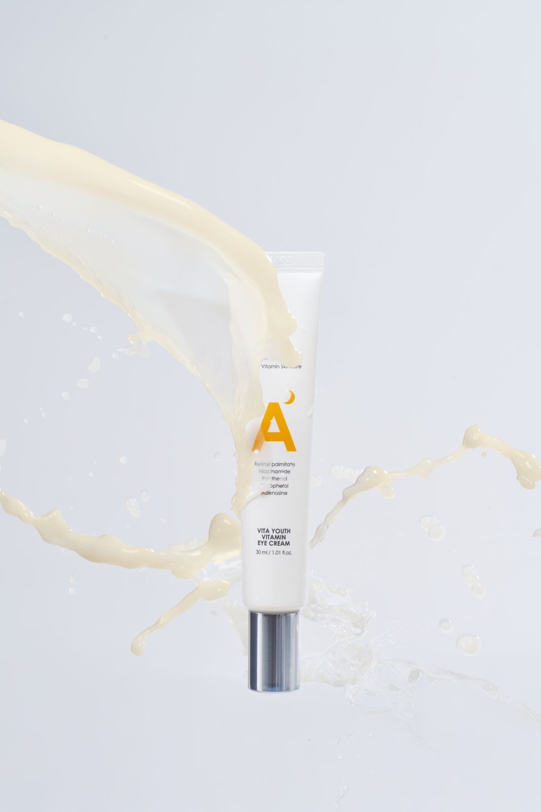 ELT COSMETIC · VITA YOUTH — 화이트 배경 위 아이크림 튜브 옆으로 크리미한 텍스처가 아치형으로 흩뿌려진 합성이펙트 연출컷