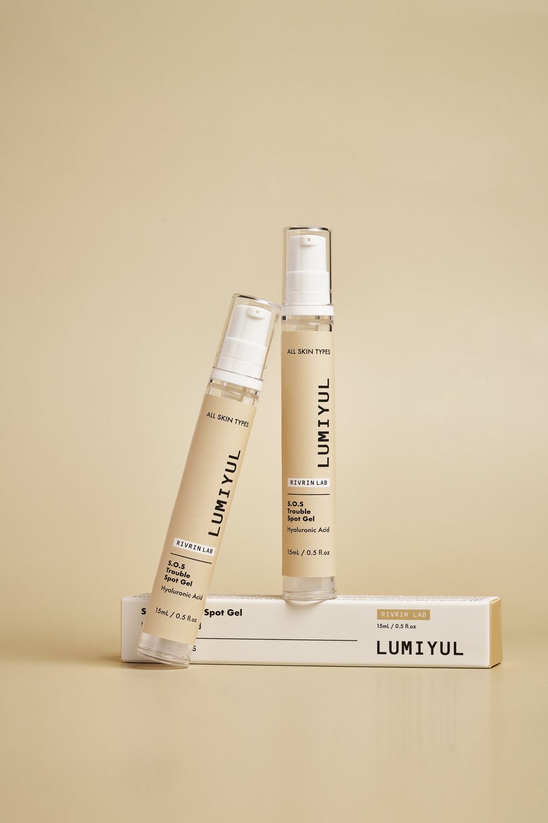 Rivrin Lab · 여드름패치겔 — 제품 2개를 박스에 기대어 세운 컷, 베이지 배경