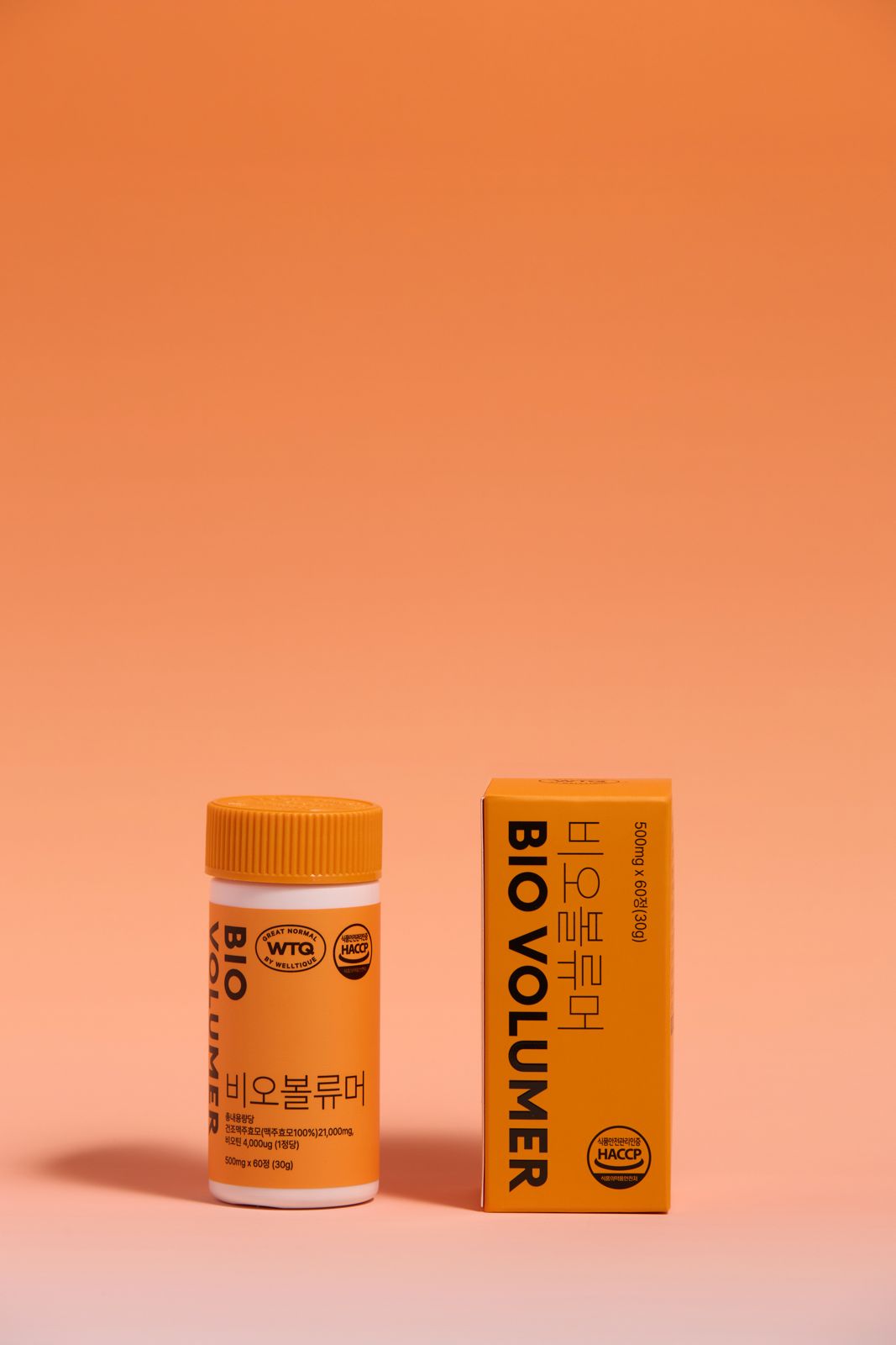 SH FOOD · 건강기능식품 — BIO VOLUMER(비오볼류머) 병+패키지 박스를 나란히 세운 단독컷, 오렌지 그라데이션 배경