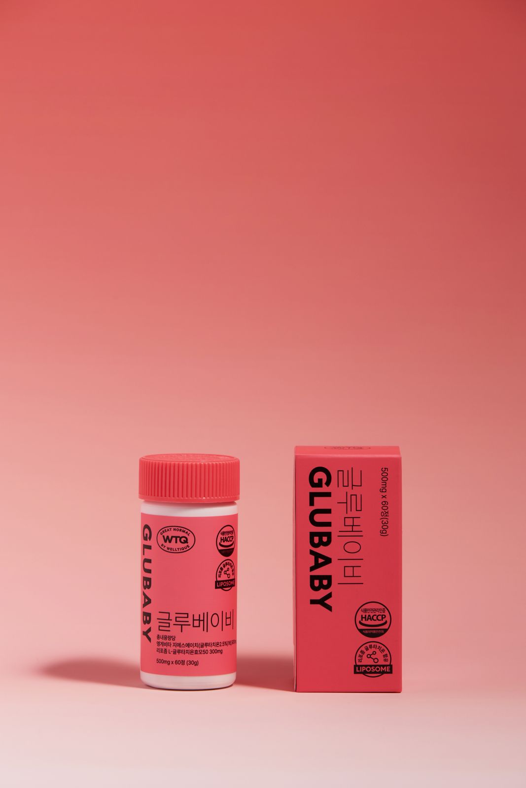 SH FOOD · 건강기능식품 — GLUBABY(글루베이비) 병+패키지 박스를 나란히 세운 단독컷, 코랄핑크 그라데이션 배경