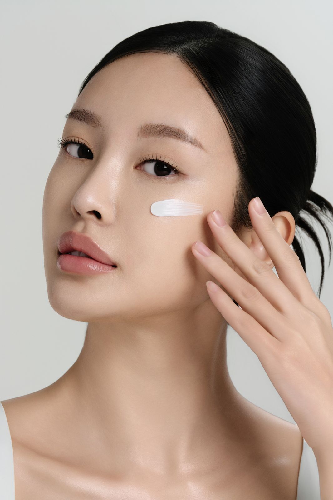 TRUHYAL100 · 모델촬영 — 크림 텍스처를 볼에 바른 채 손가락을 뺨에 댄 클로즈업 모델컷