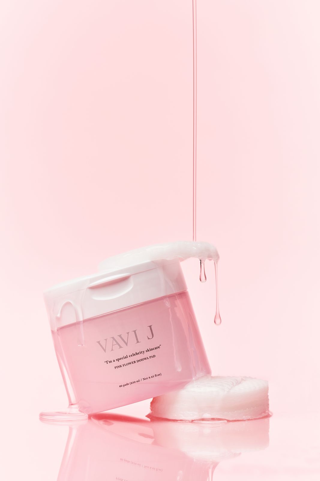 VAVIJ · 도화패드 — 제형이 흘러내리는 용기와 패드를 함께 놓은 컷