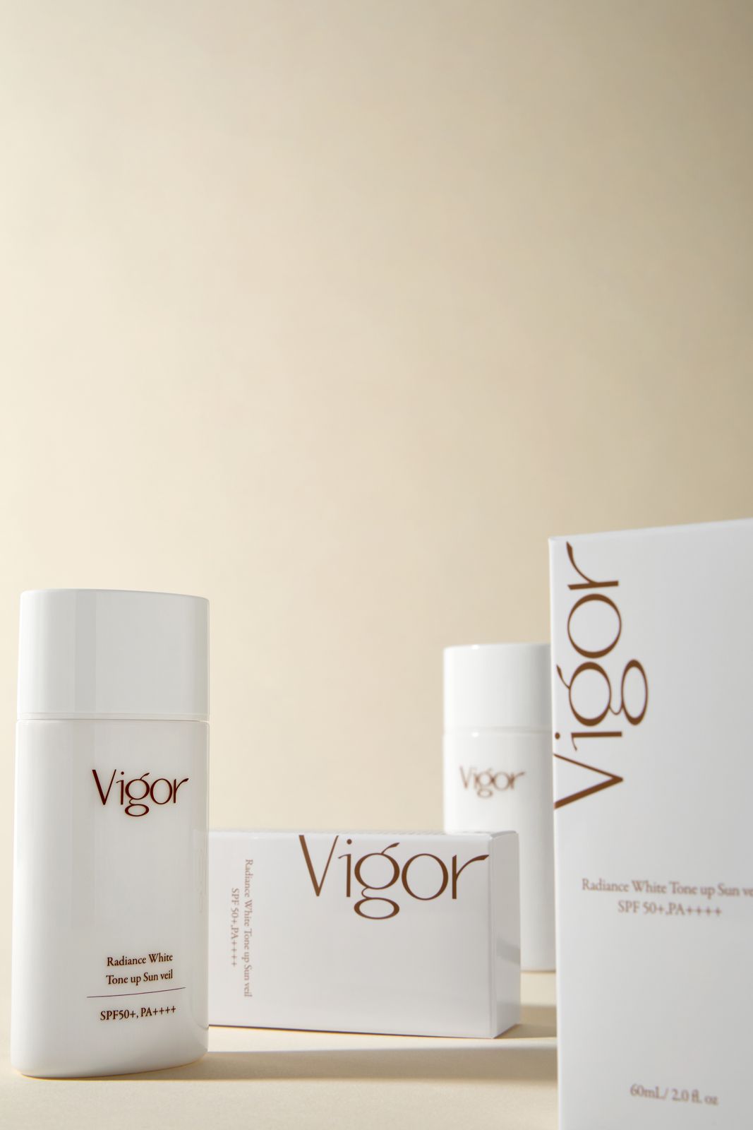 VIGOR · 선크림 — 두 사이즈 제품과 박스를 함께 놓은 그룹컷
